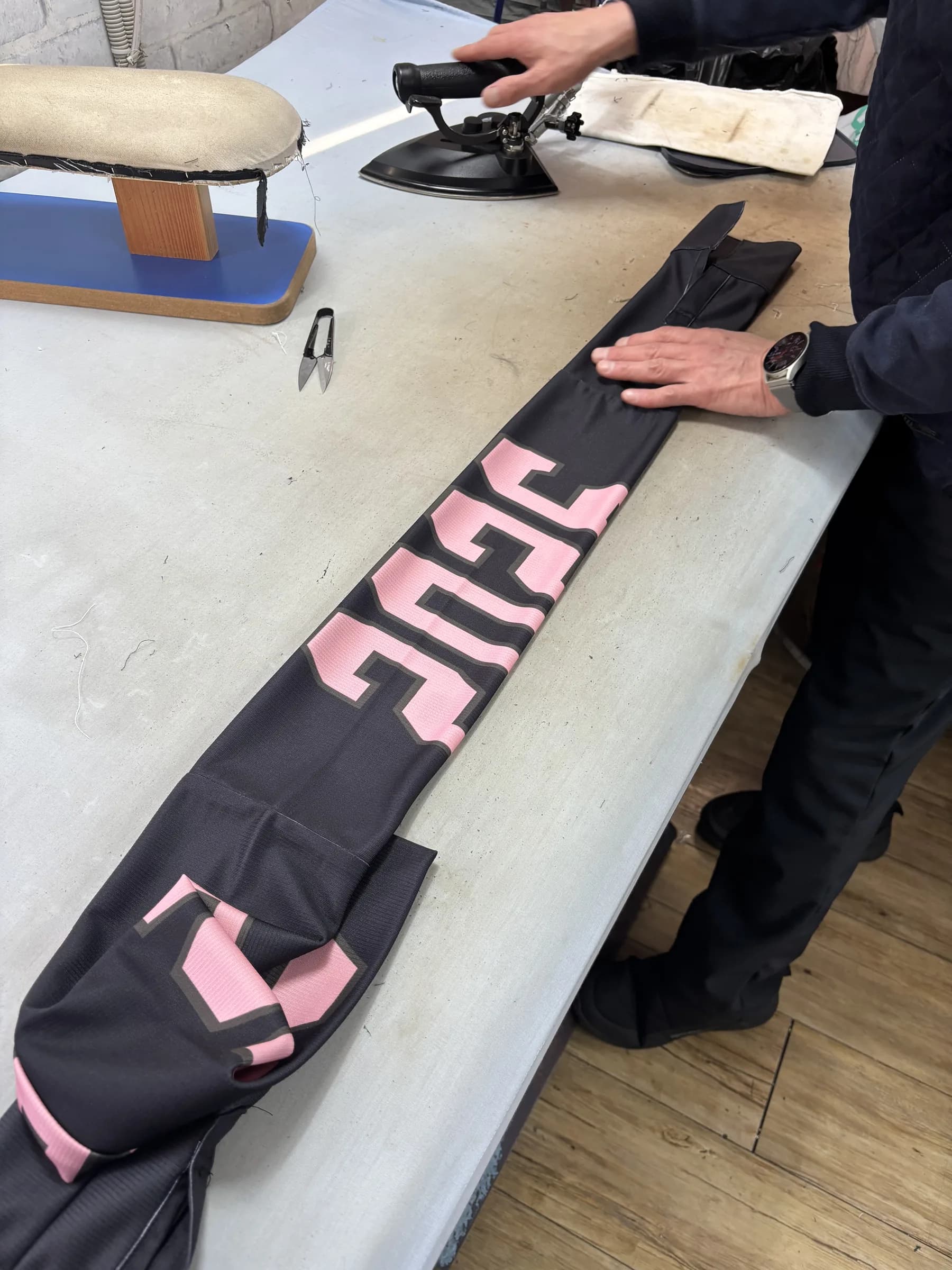 Heat-pressing the "2026" print onto a tour piece